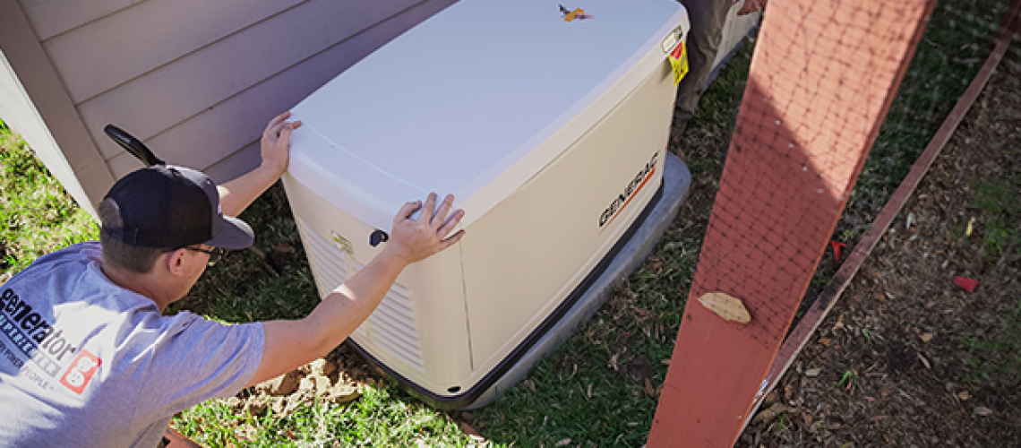 Technician installing a Generac standby generator beside a home